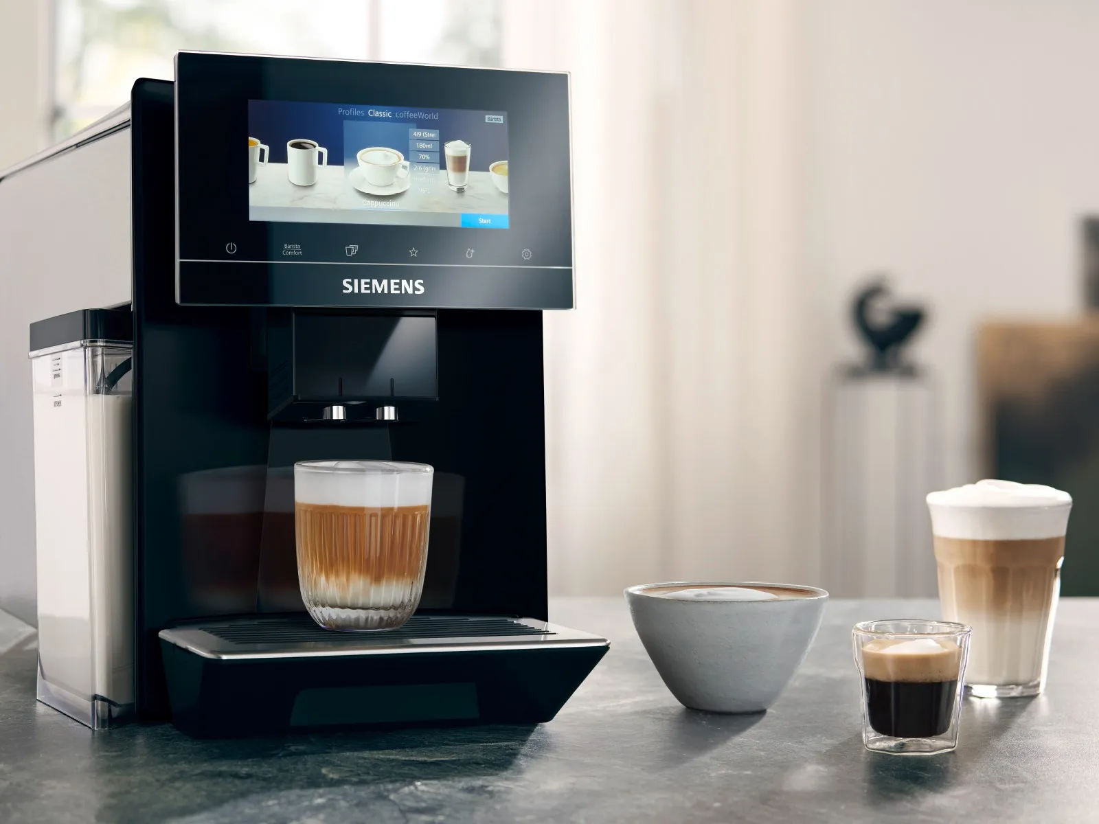 Una cafetera superautomática Siemens prepara un café, acompañada de un cuenco con más café y dos vasos de espresso y latte