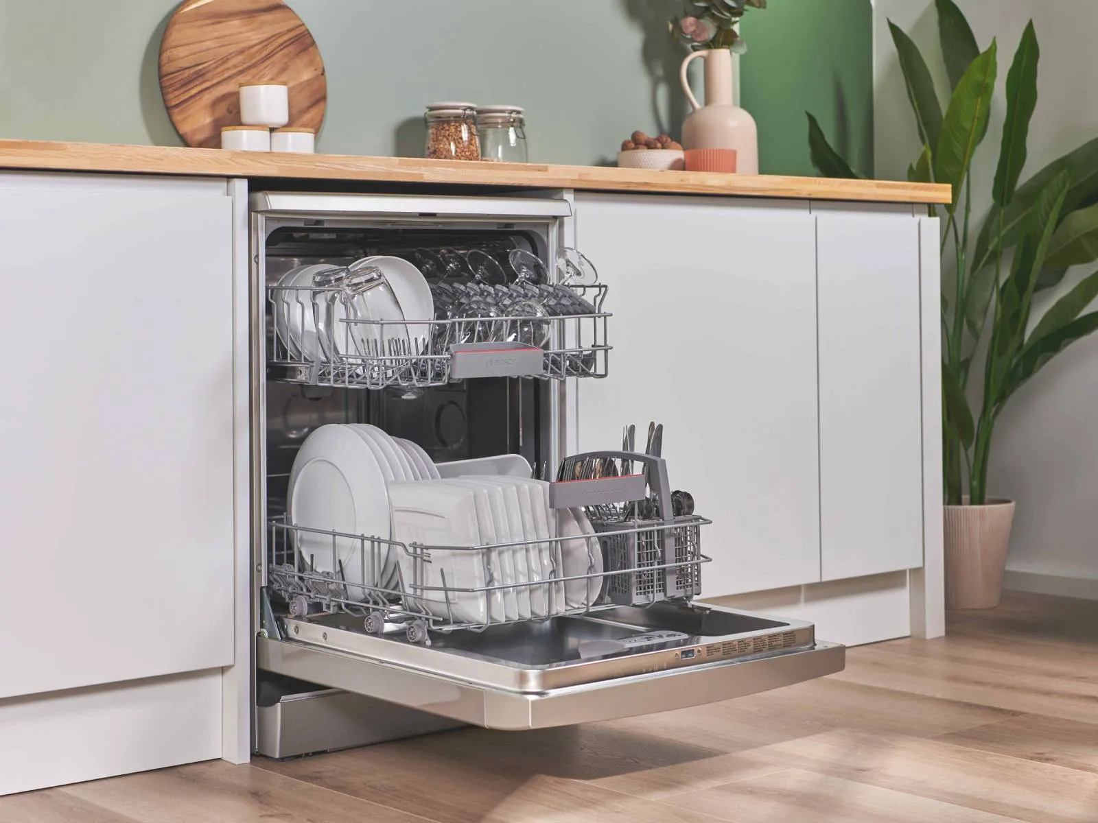 Modern kitchen with an open dishwasher seamlessly integrated into white cabinetry. A custom solution for any kitchen design.