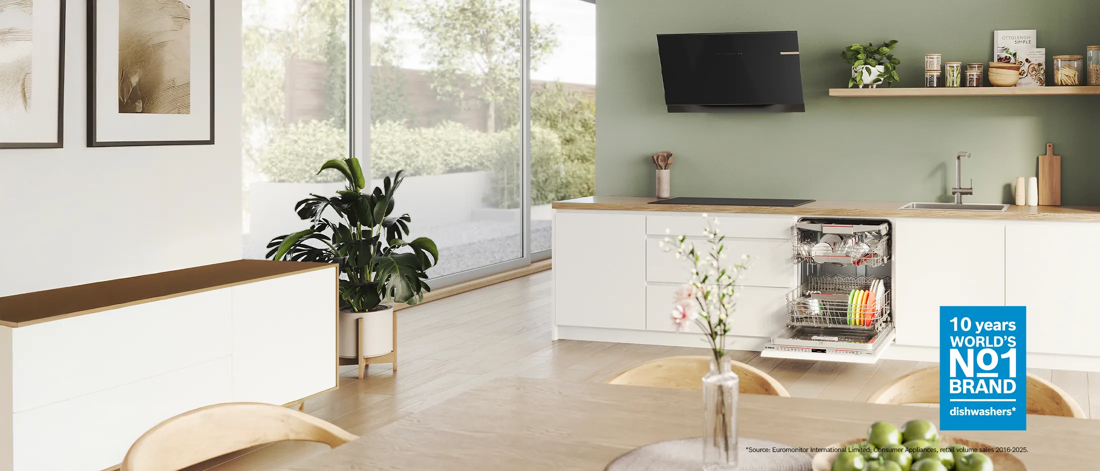 A modern kitchen featuring an open dishwasher loaded with clean dishes.
