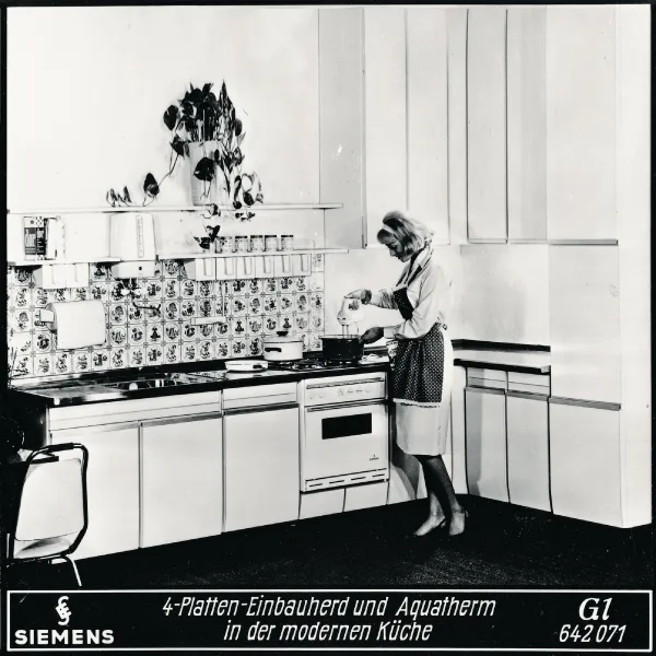 A black and white photo of a woman cooking in a vintage Siemens kitchen, with text "4-Platten-Einbauherd und Aquatherm in der modernen Küche".