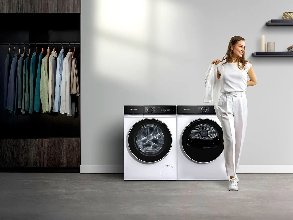 Man sitting on couch tying his shoes in a living room with furniture and decor.