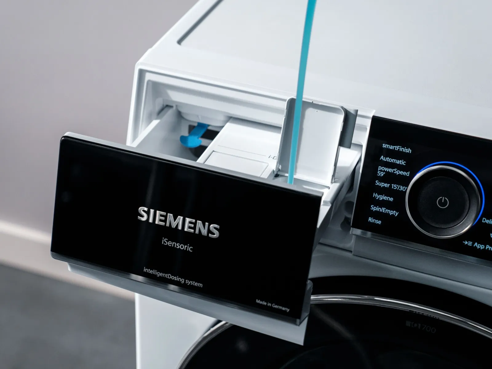 Homme dosant du détergent dans un lave-linge Siemens.