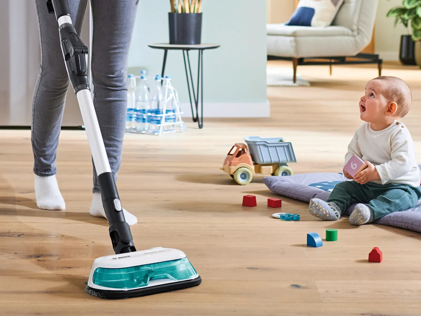 Eine Person reinigt den Fußboden mit einem Unlimited 7 ProHygienic Aqua Akku-Staubsauger mit Wischfunktion.