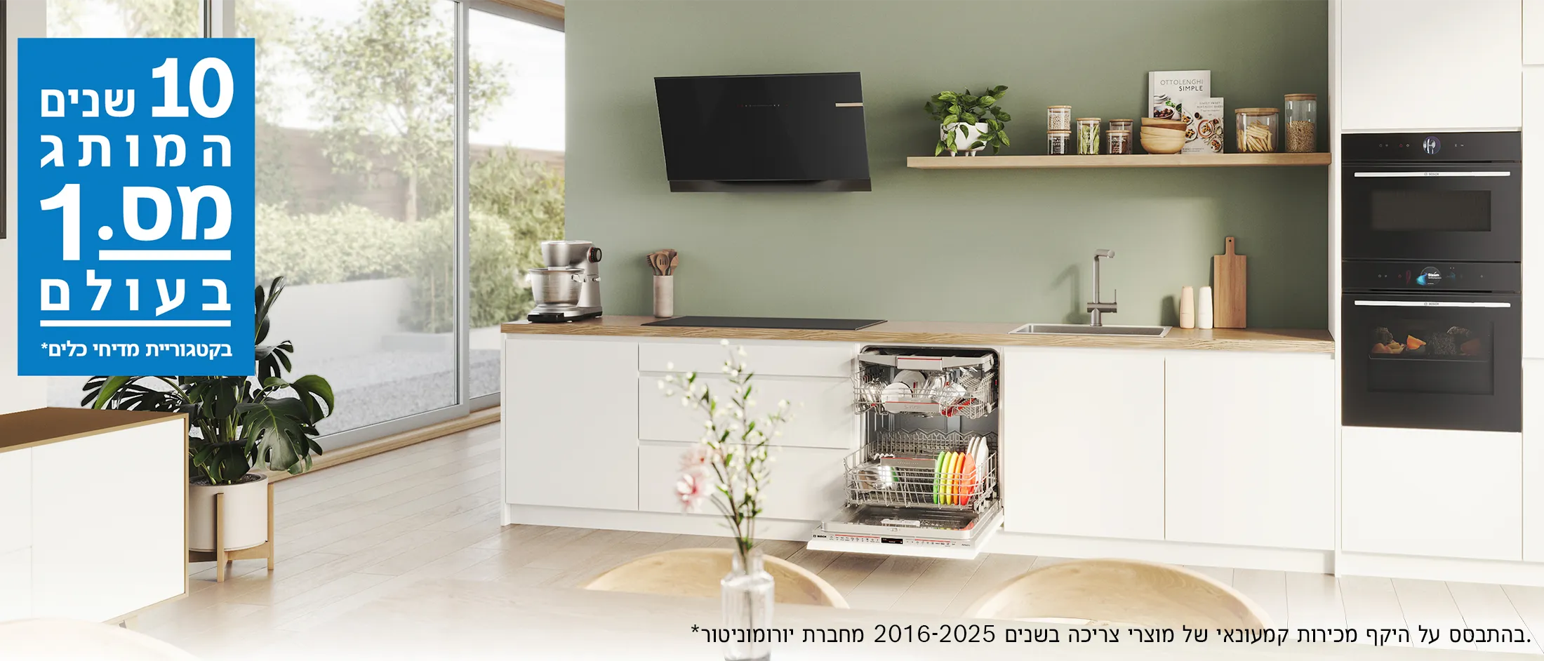 מטבח מודרני עם קירות ירוקים, מדיח כלים פתוח, מכונת מיקסר, כיריים וכיור. על השולחן קופסאות זכוכית עם חומרי מזון.