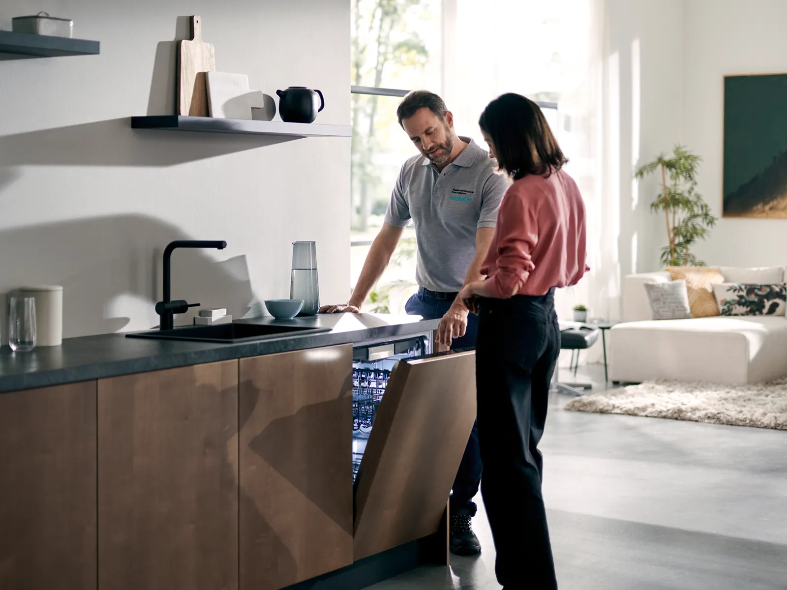 Two people discussing kitchen design in a modern, well-lit home interior.