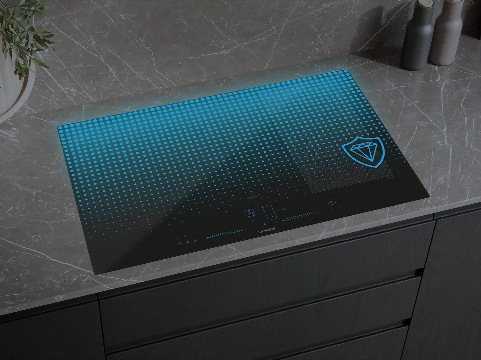 A black Siemens induction cooktop with a vibrant blue illuminated dotted pattern and a diamond shield logo, set into a dark marble countertop.