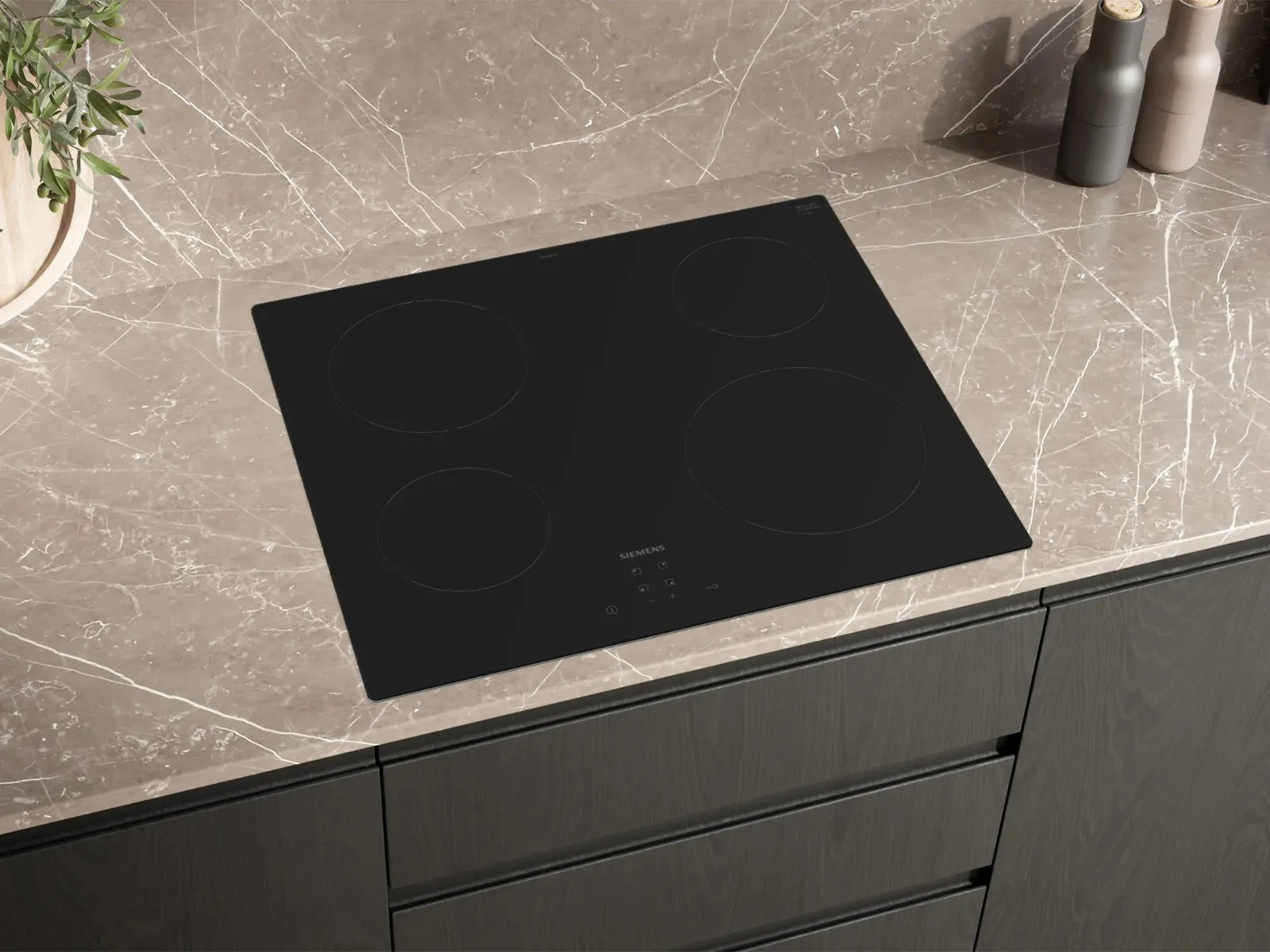 A sleek black Siemens induction cooktop with four cooking zones and touch controls, integrated into a light brown marble-patterned countertop in a modern kitchen.