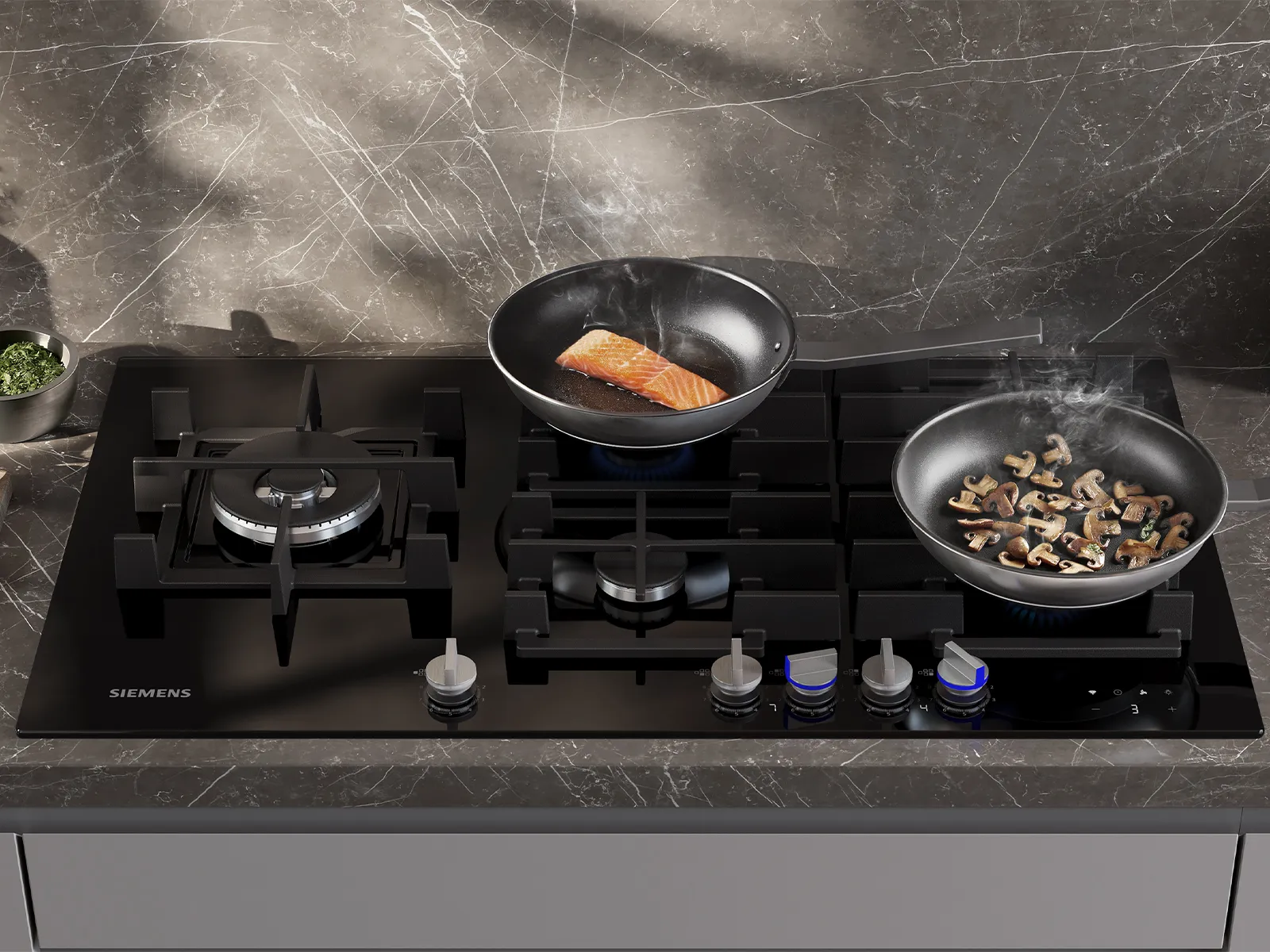 Gas stove top with black glass surface and metal burners on wooden kitchen counter.