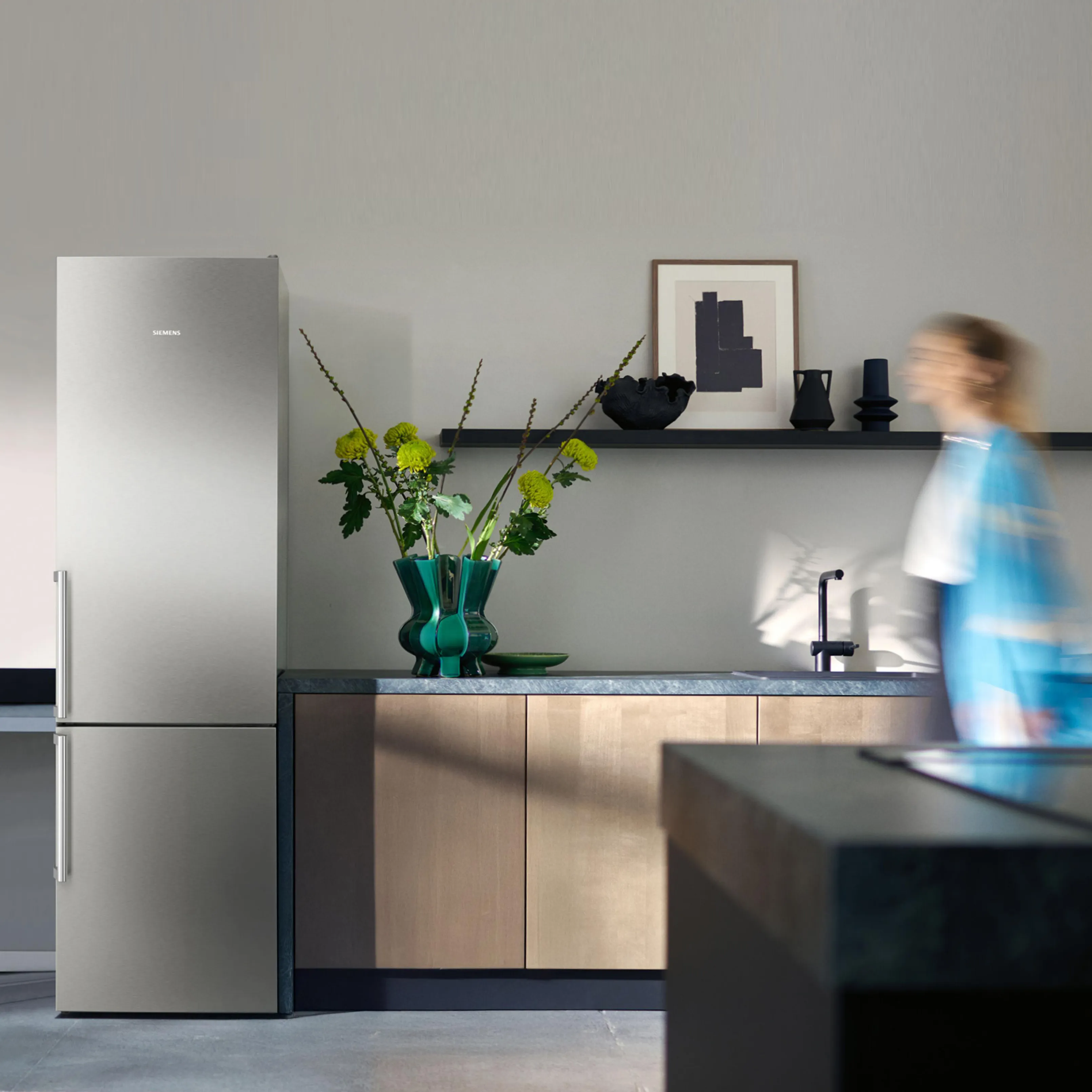 Jasna kuchnia, lodówka, idąca kobieta