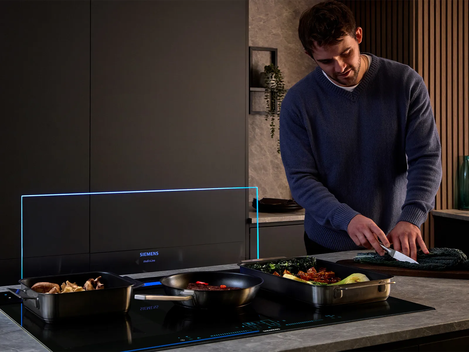 A man cooks in a kitchen, with steam rising from the stove, creating a warm and inviting atmosphere. 