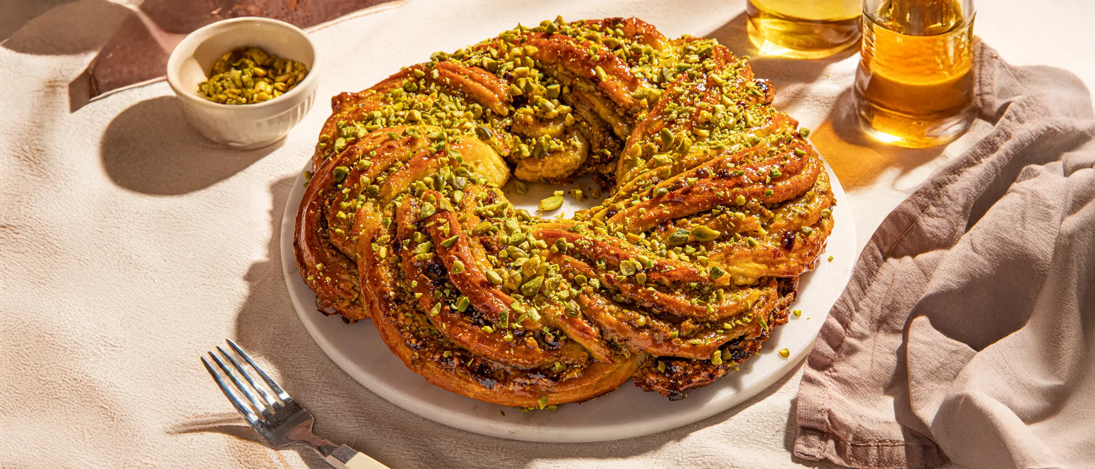 Golden brown baked braided Easter bread with pistachio and cranberry filling formed like a wreath.