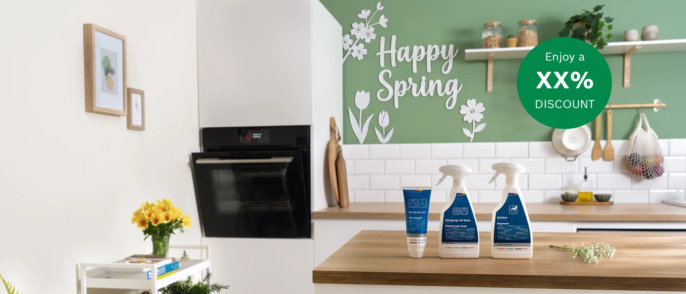 Bright kitchen scene with cleaning products on a wooden counter, "Happy Spring" text, and a discount offer on a green wall.