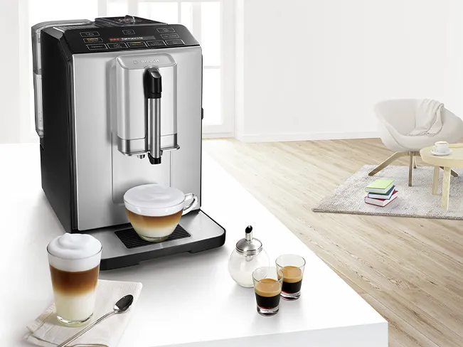 Kahve makinesi bardak, kitaplar ve modern oturma odasında sandalye.