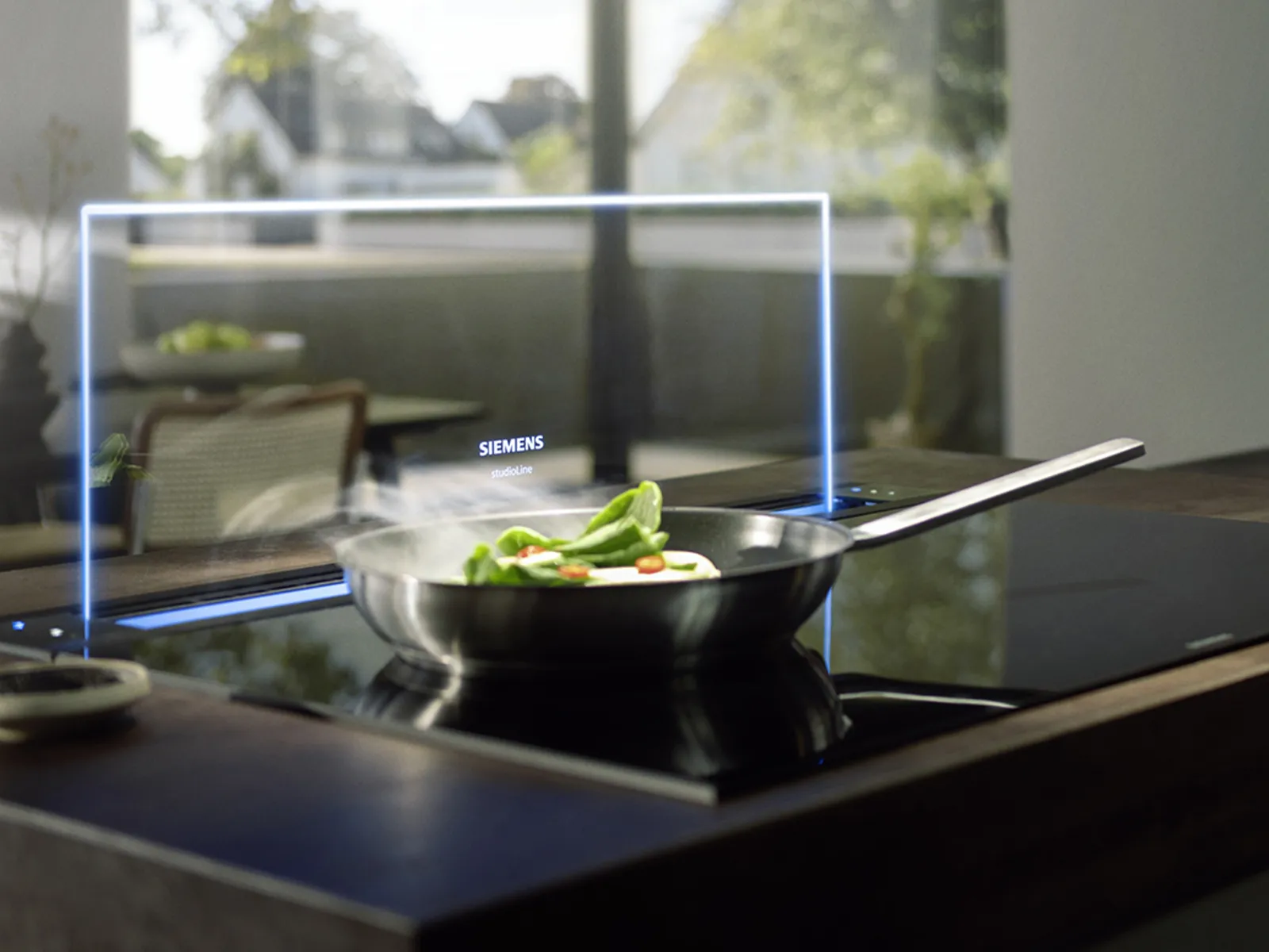 A modern induction cooktop with a pot of boiling water, featuring a sleek design and integrated ventilation system above.