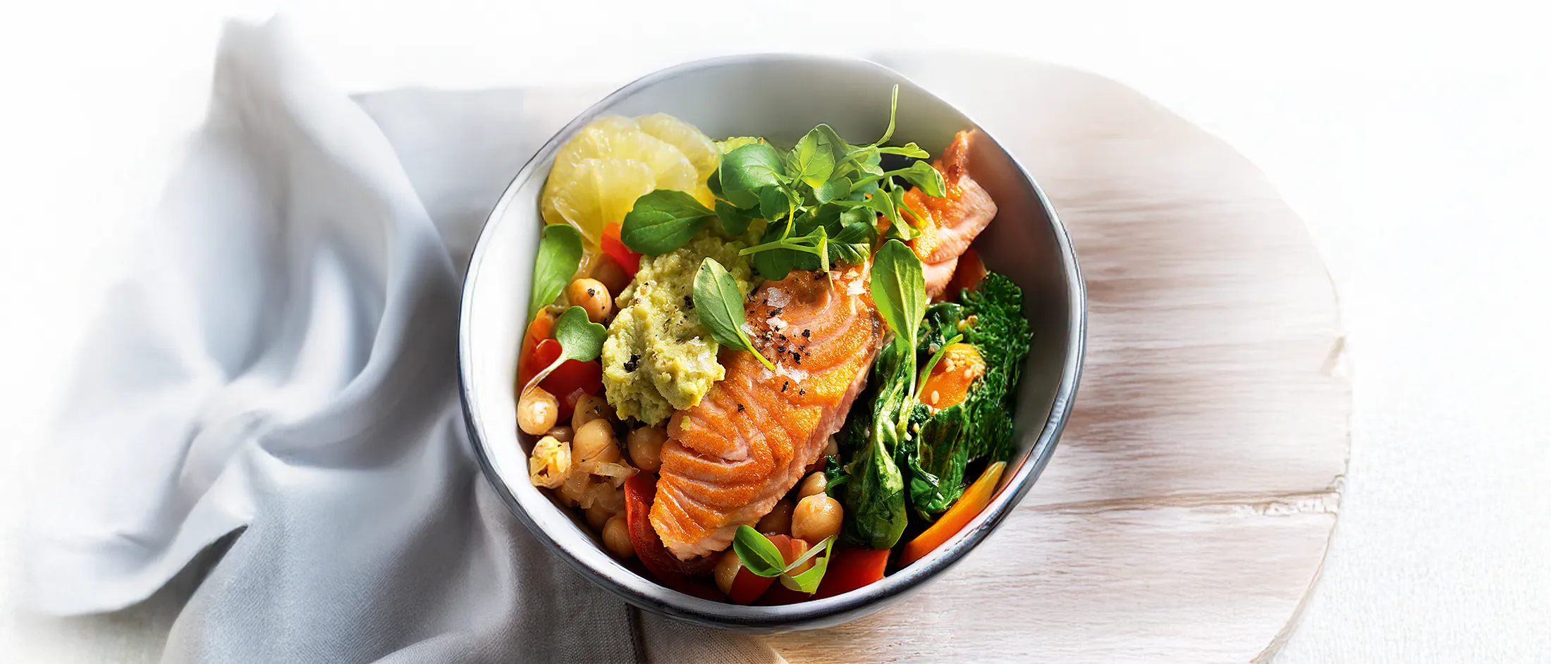 Salmon chickpea bowl with greens, lemon slices, and a dollop of green sauce, labeled "Healthy Dinner" by Bosch
