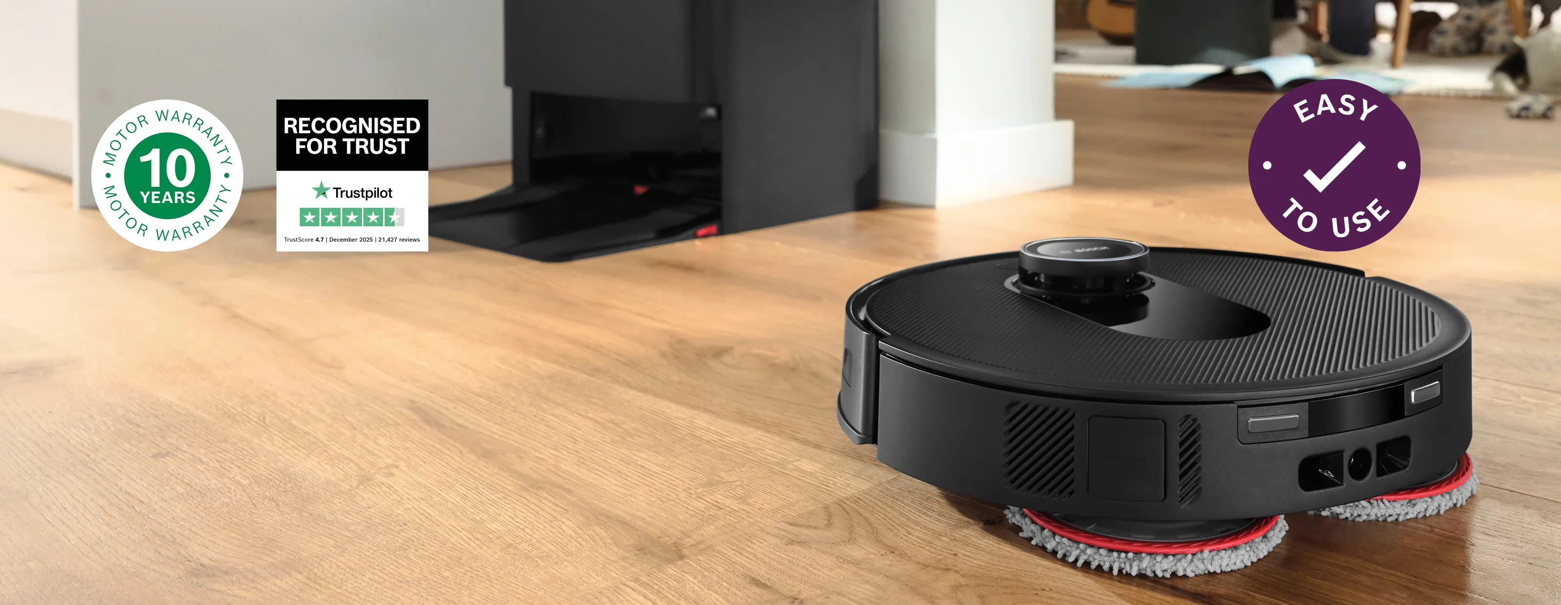 A sleek Bosch robotic vacuum rests gracefully on a polished hardwood floor, while a joyful family shares quality moments around the dining table in the background.