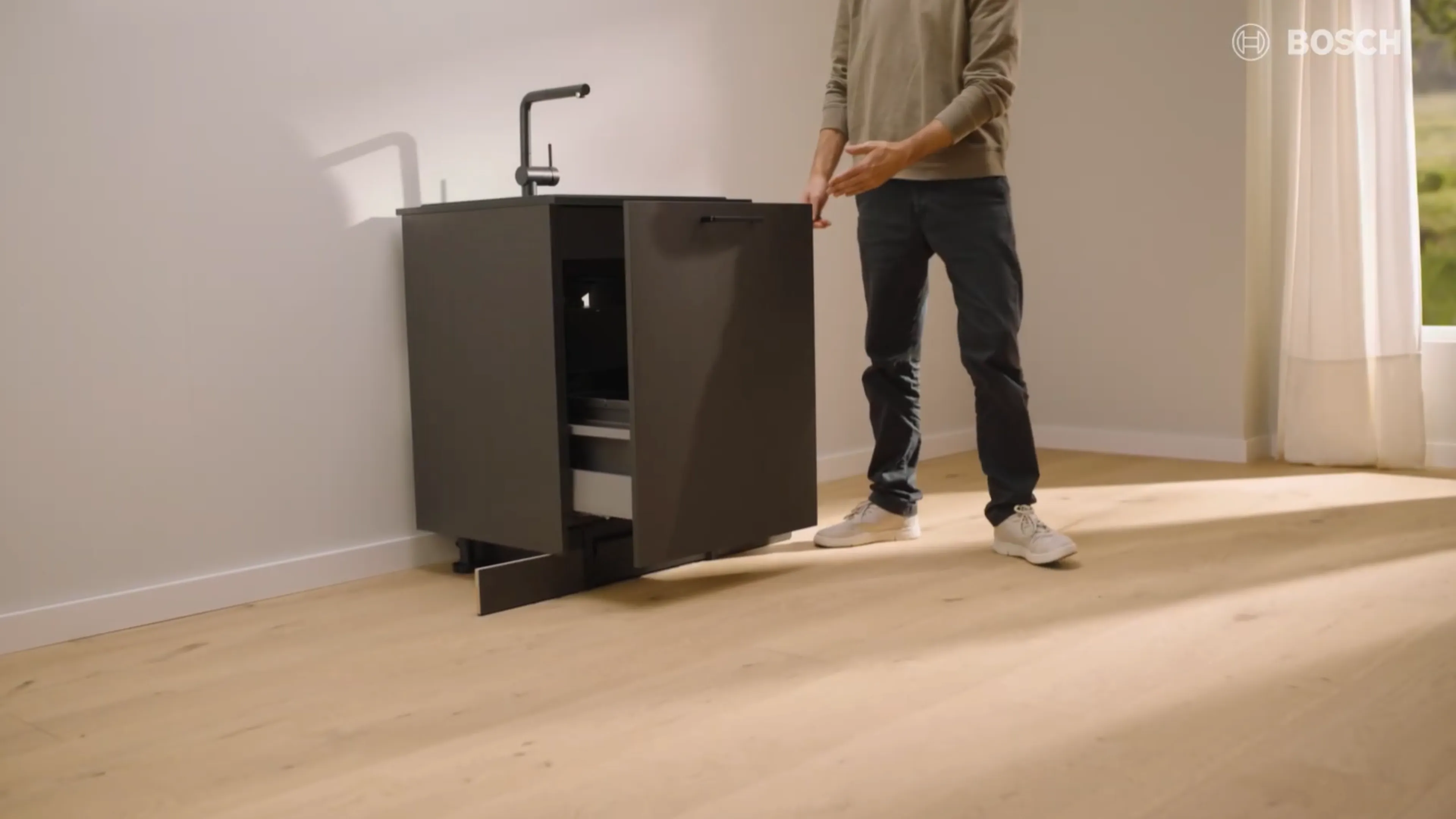 Una copertina della guida all'installazione Bosch che mostra un elegante robot di pulizia integrato sotto un moderno lavandino contro una parete minimalista e di colore chiaro.