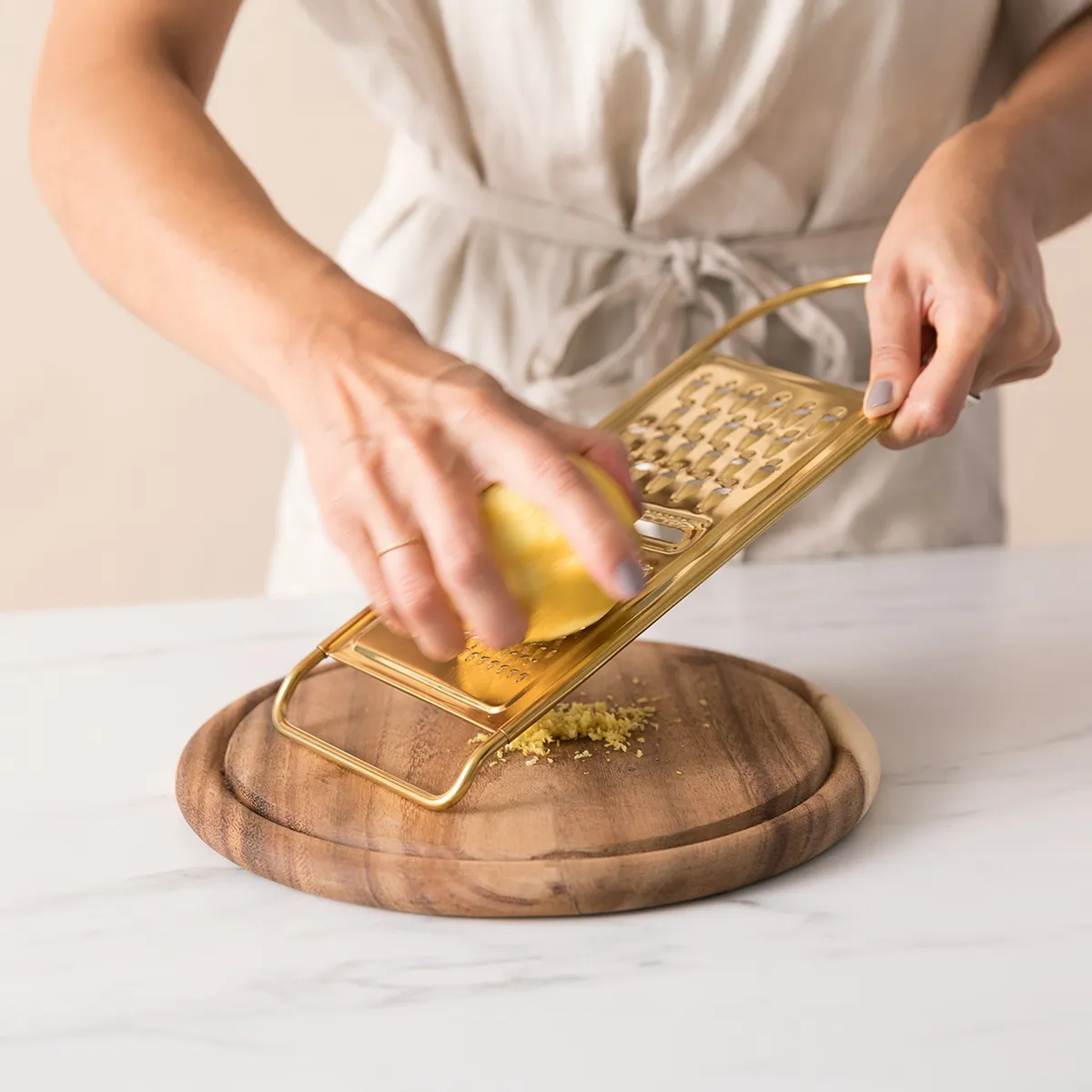 Hand grating lemon zest over fresh raspberries on a wooden board while preparing raspberry sorbet.