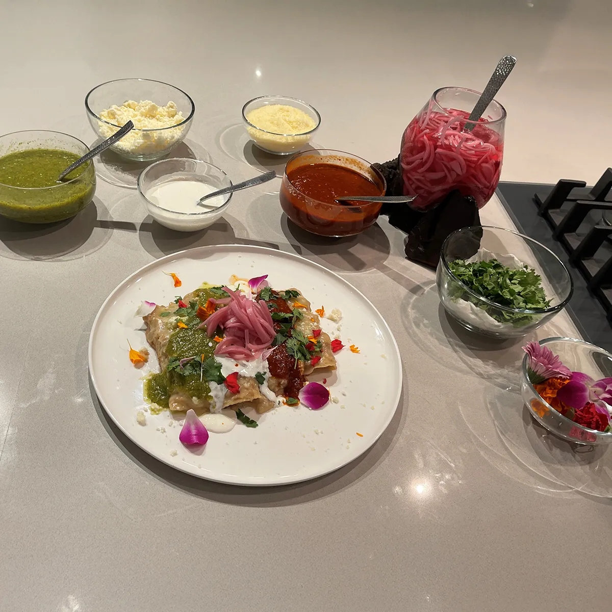 Colorful plate with various ingredients, including greens, pickled onions, and edible flowers.