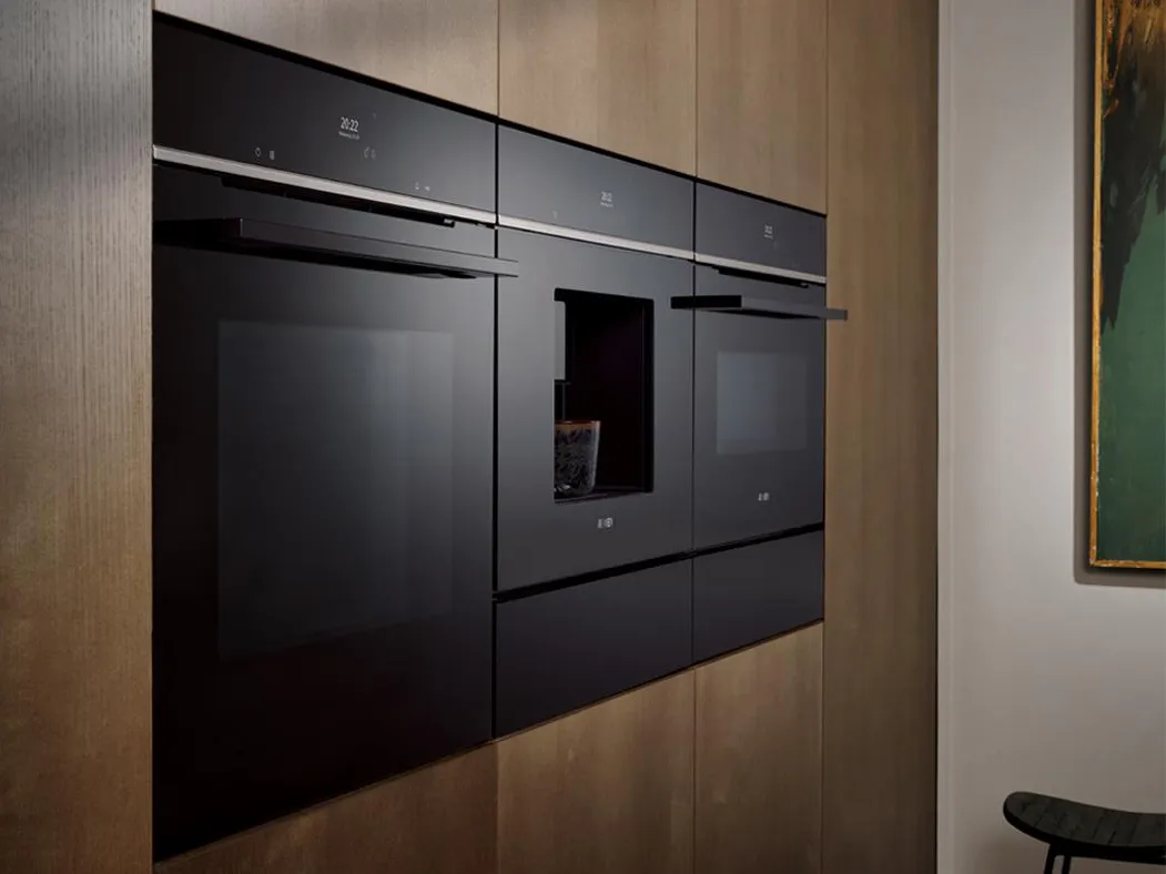 Trzy eleganckie czarne urządzenia kuchenne marki Siemens wkomponowane w ciemne drewniane panele, prezentujące nowoczesny design i zaawansowaną technologię.