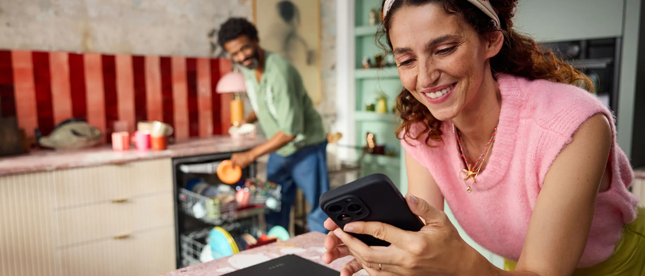 Two people preparing food in a modern kitchen with appliances and decor.