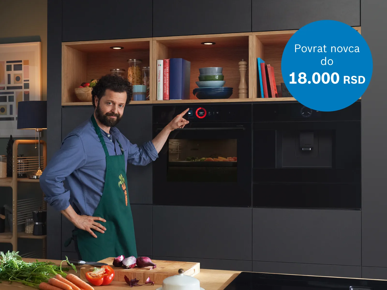 Čovek ispred rerne sa  svežimnamirnicama na stolu u modernoj kuhinji