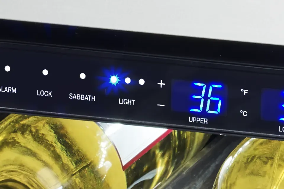 Close-up of a digital control panel on a wine cooler displaying temperature 36°F