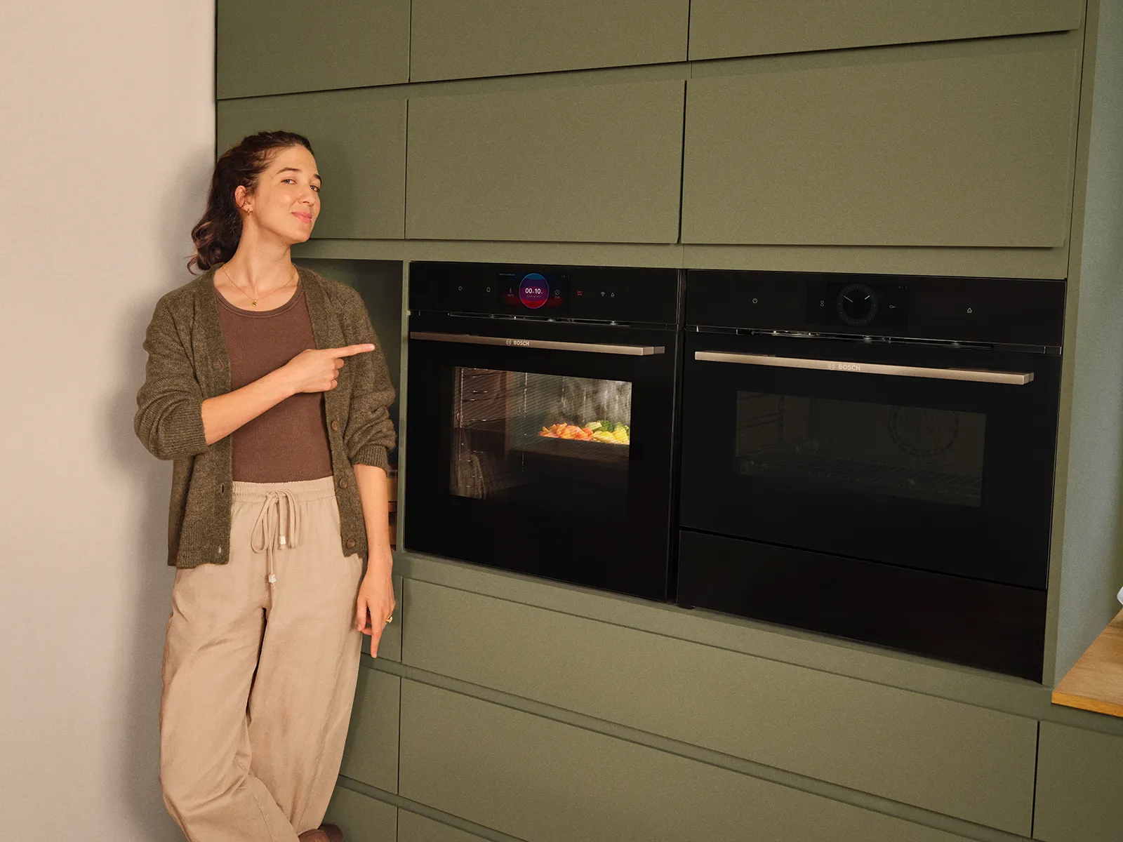 Mujer señalando un horno bosch en funcionamiento