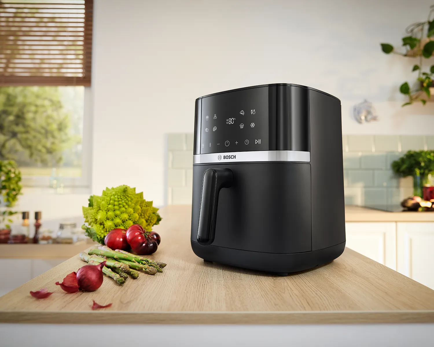 A Bosch Air Fryer Series 4 stands on a modern kitchen counter, viewed from the front, ready for cooking.