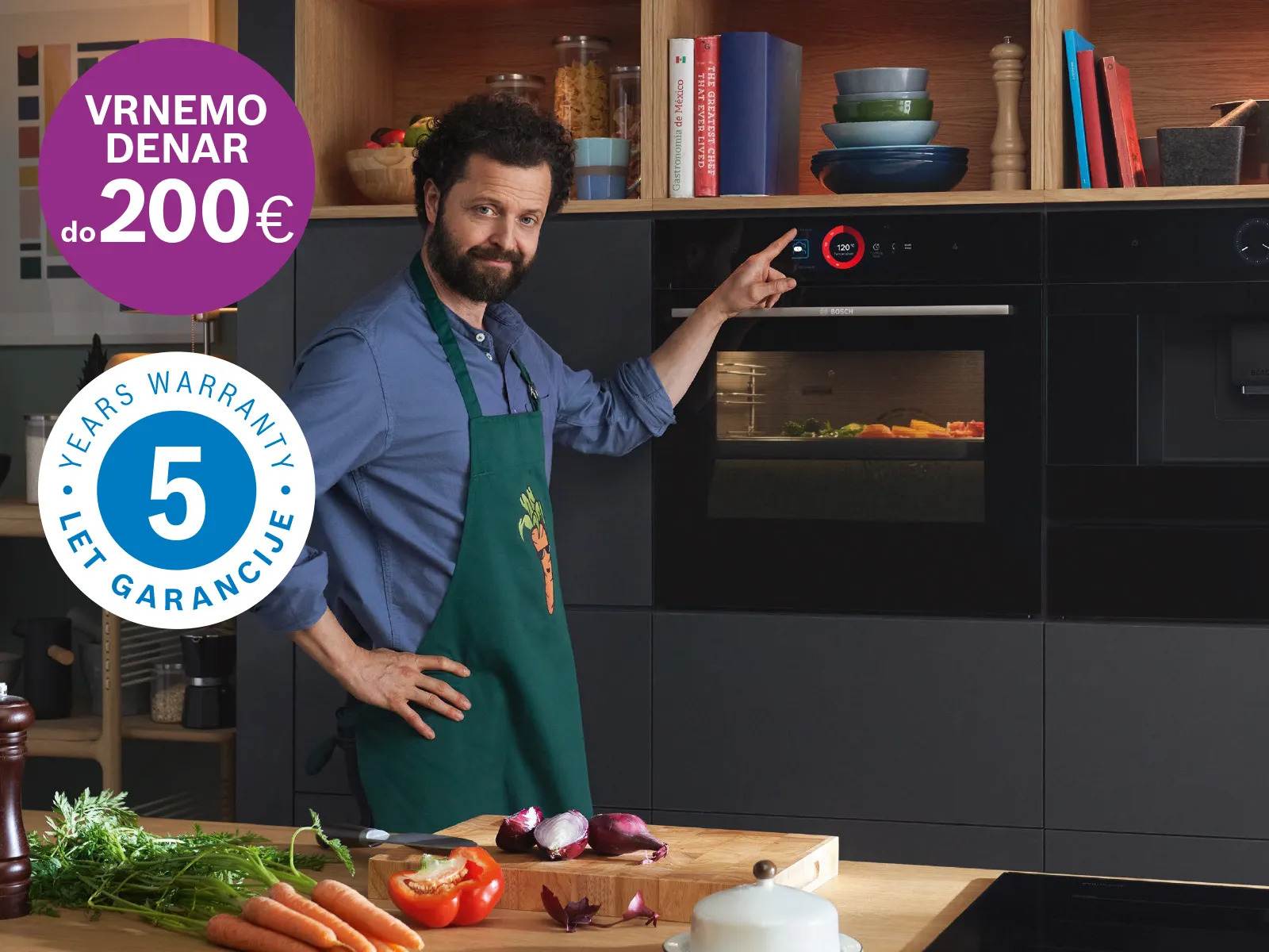 Moški v kuhinji kaže na Bosch pečico z značkama: vrnemo denar do 200 € in 5 let garancije.