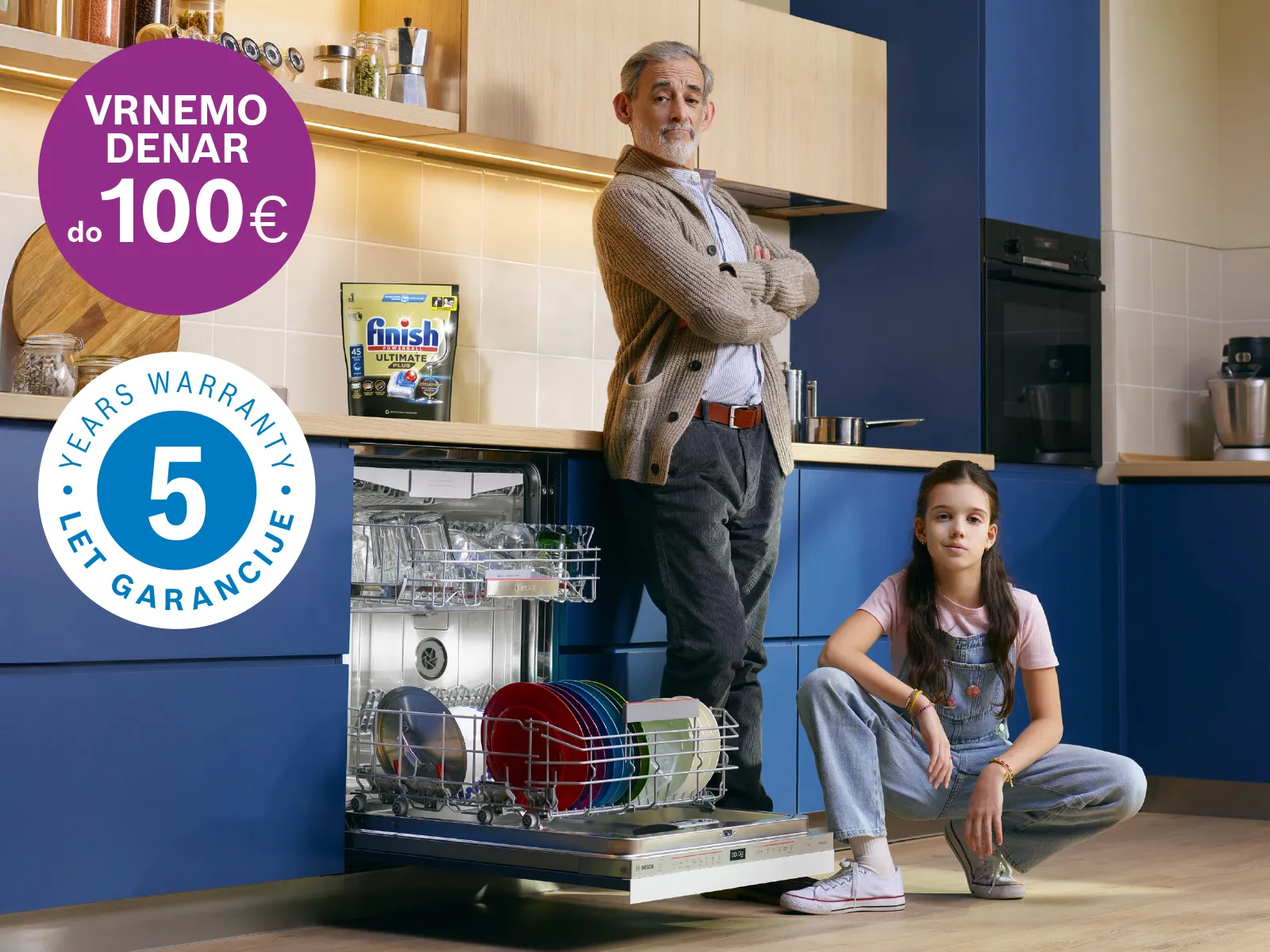 Dedek in vnukinja ob vgradnem pomivalnem stroju Bosch in Finish tabletah.