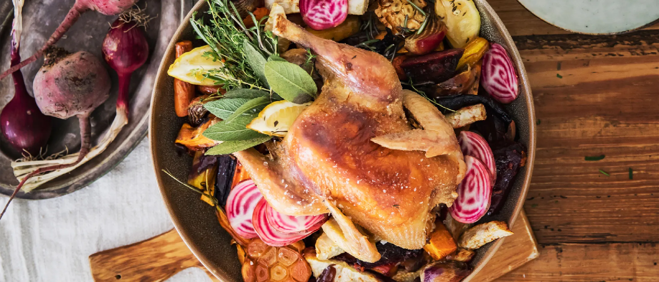 Pollo arrosto con verdure arrosto assortite su un tavolo di legno