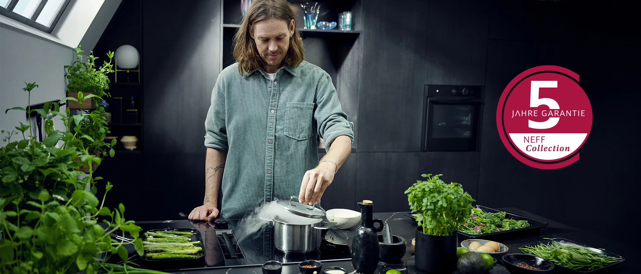 Koch in moderner NEFF Collection Küche beim Kochen am Herd mit 5 Jahre Garantie Hinweis