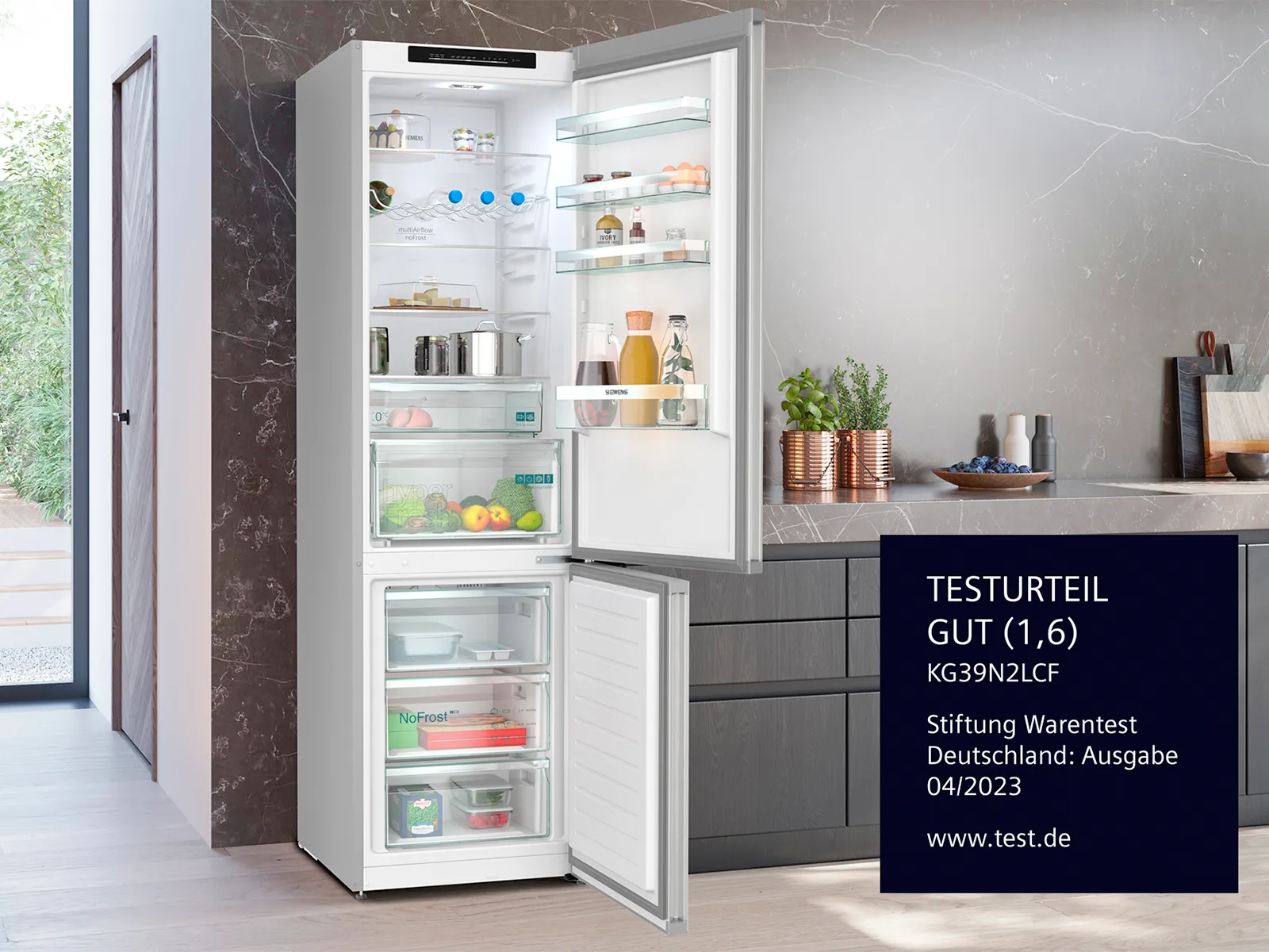 Offene weiße Kühl- und Gefrierkombination in moderner Küche mit Testurteil „Gut (1,6)” von Stiftung Warentest, Deutschland, 04/2023.