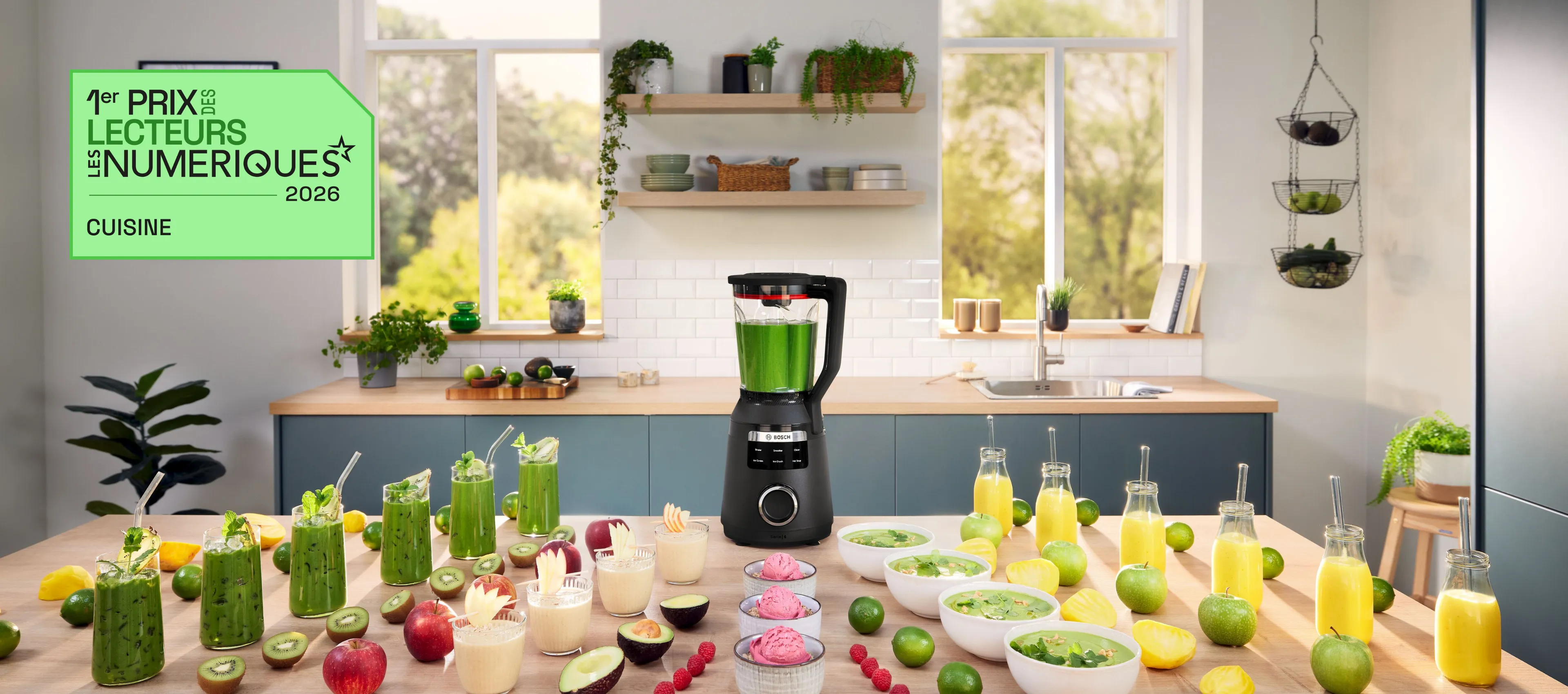 VitaPower Série 6 entouré de verres de smoothies verts, d'avocats et de citrons verts sur la table de cuisine.