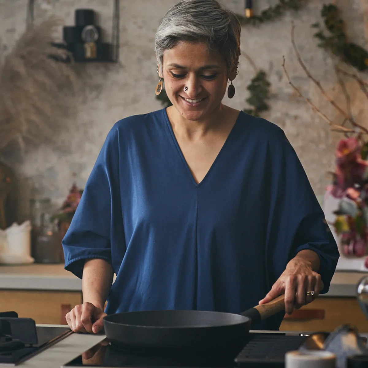 Άτομο μαγειρεύει σε μοντέρνα κουζίνα με κομψή διακόσμηση.