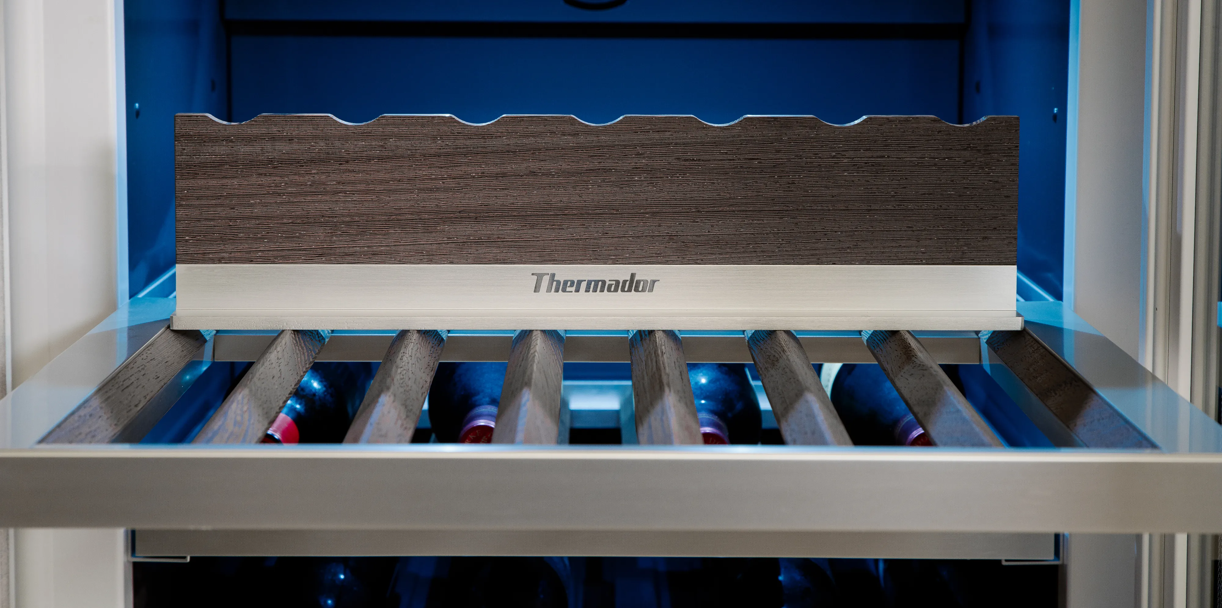 Roller conveyor inside a Thermador appliance, designed for easy loading and unloading of cookware or food trays.
