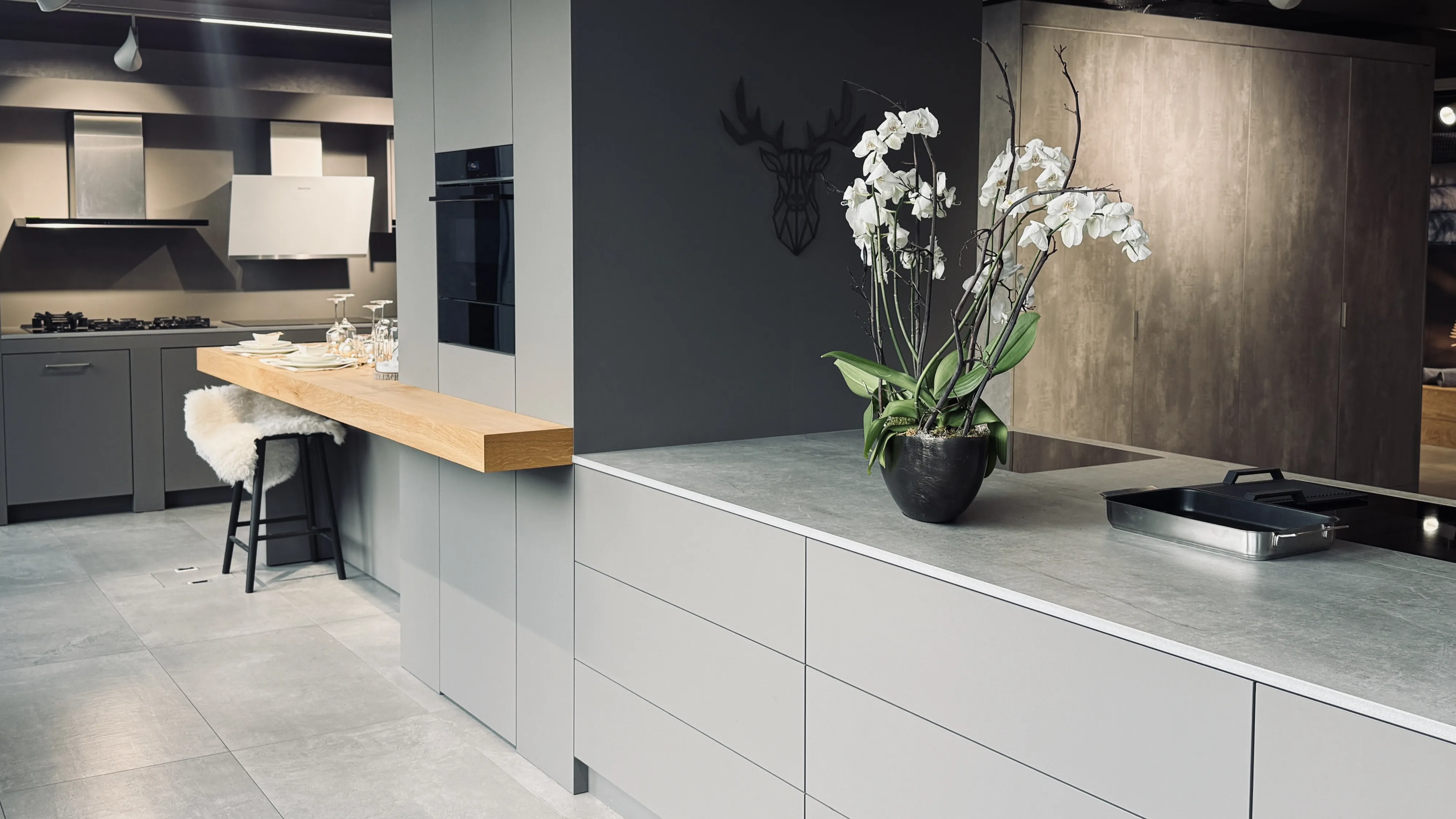 Moderne Küche mit eleganten schwarzen Arbeitsplatten, Edelstahl-Geräten und Holzschrankerei.