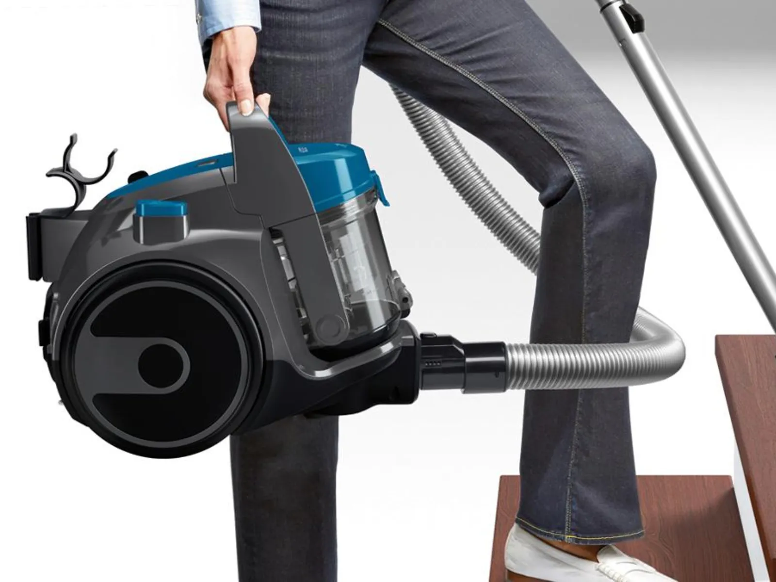 Ein Mensch saugt mit einem beutellosen Staubssauger von Bosch der Serie 2 auf einer Treppe.