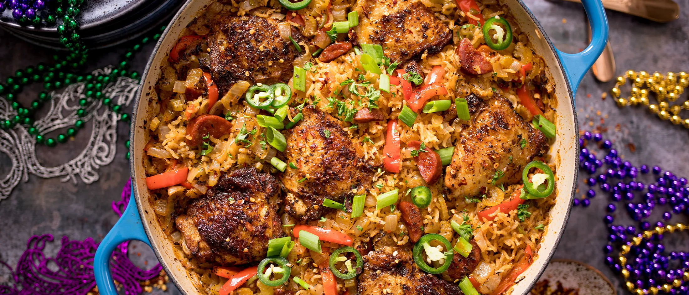 Curioso stufato di carne e verdura in un piatto di servizio colorato e festivo con perline Mardi Gras.