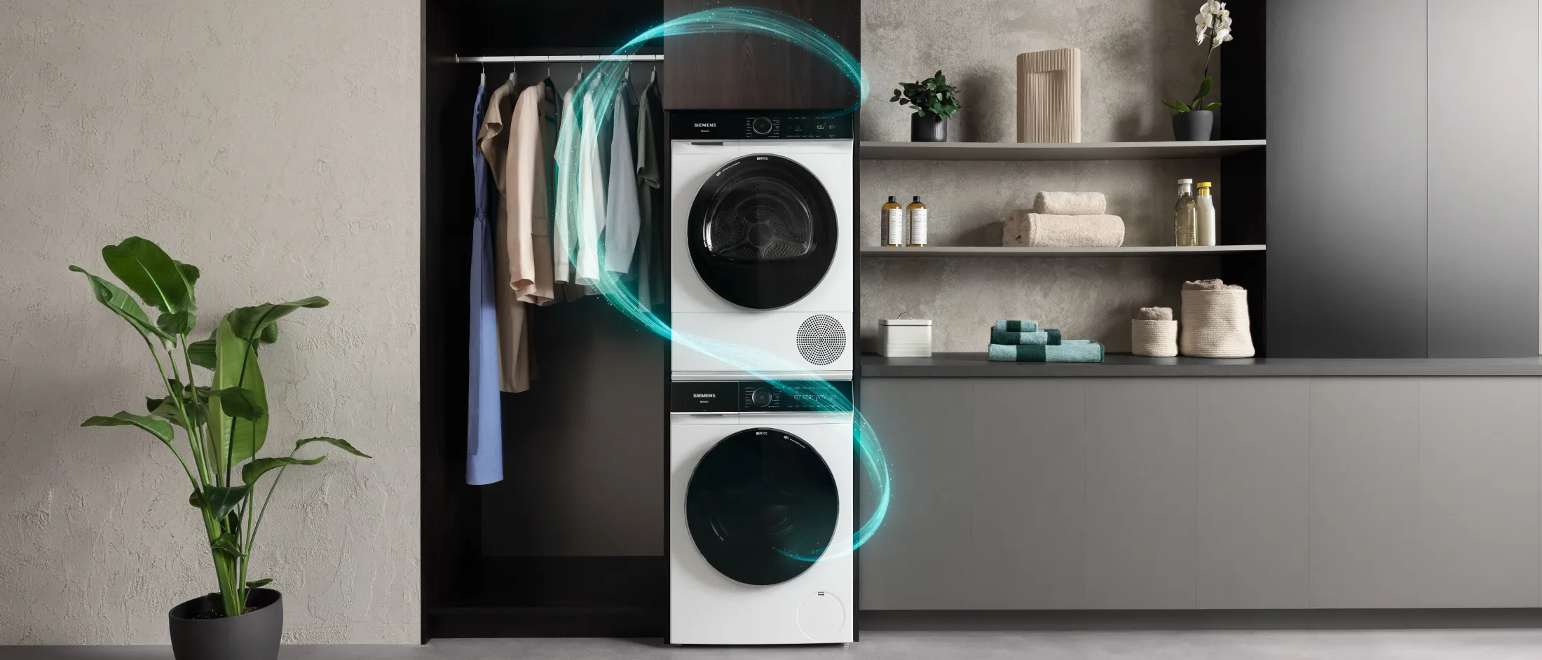 Modern laundry room with award-winning washer and dryer, shelves with towels, and clothes hanging.