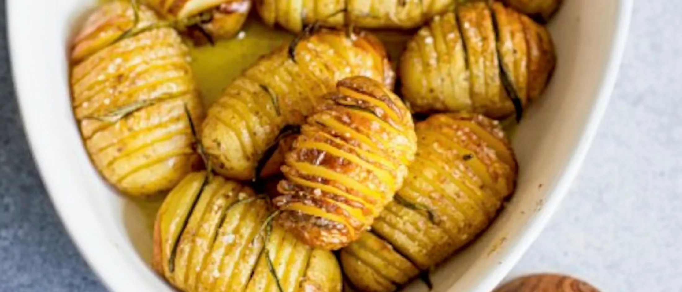 Geröstete Kartoffeln mit knuspriger Haut und goldbrauner Farbe, serviert in einer weißen Schale.