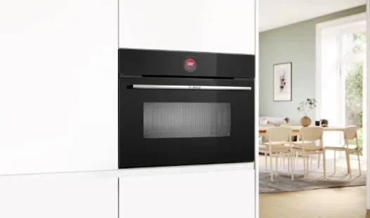 Sleek Bosch built-in oven with a stainless steel panel, digital display, and a black glass door. Modern and stylish kitchen appliance.