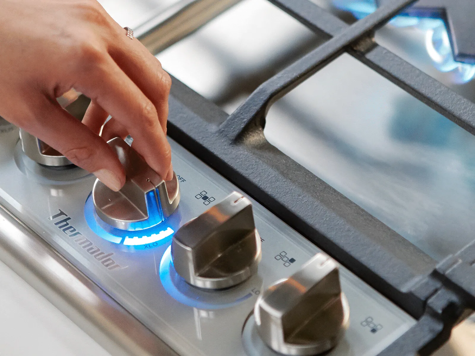 Hand adjusting stove knob.