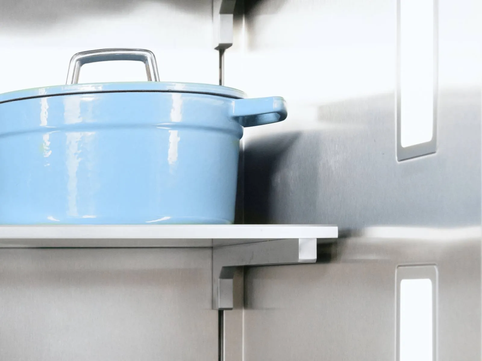 Close-up inside a stainless-steel refrigerator showing a white shelf holding a light blue enameled pot with lid; vertical LED lights and reflective interior visible.