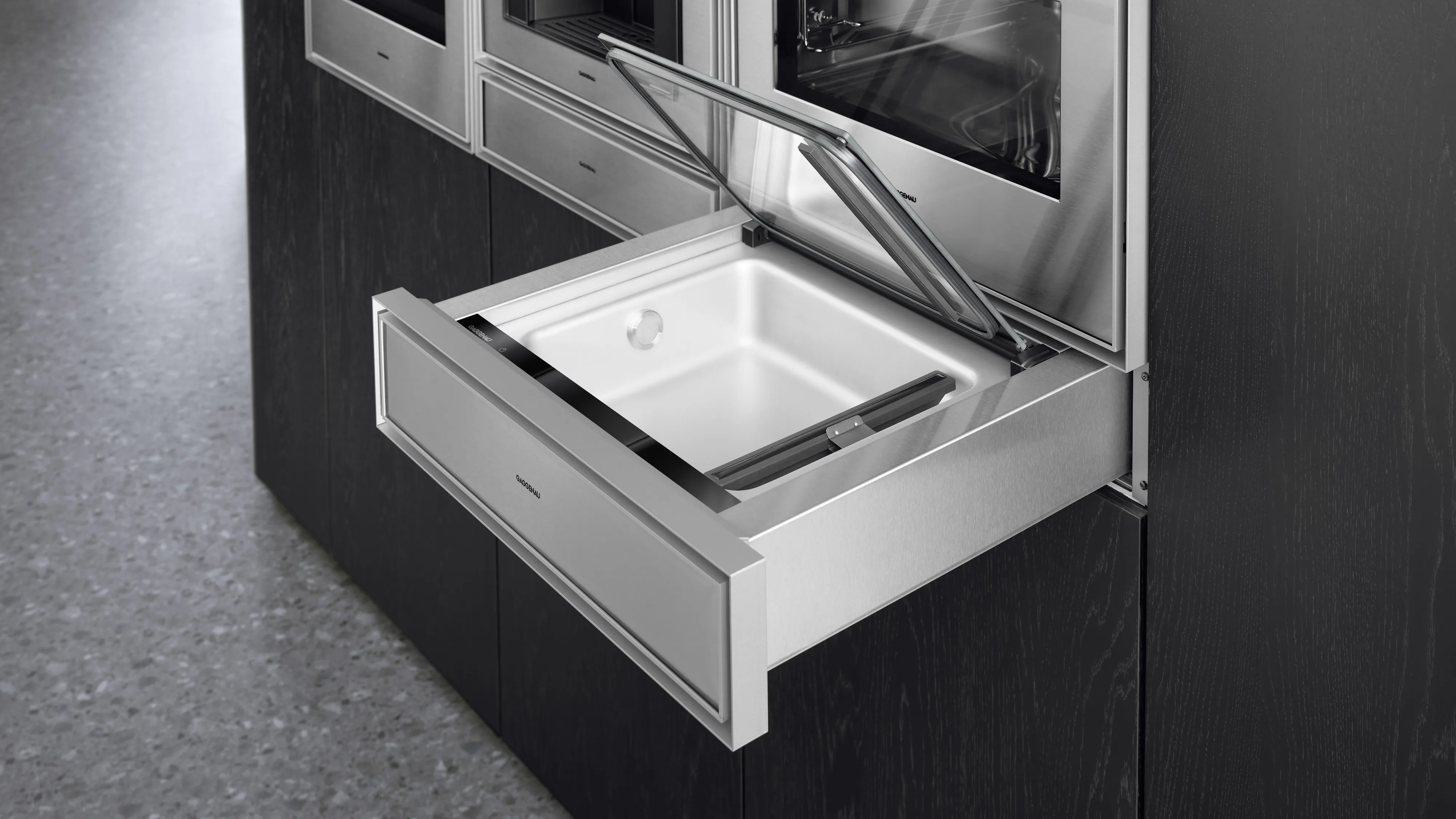 An open Gaggenau Expressive series Vacuuming drawer surrounded by other Expressive series appliances