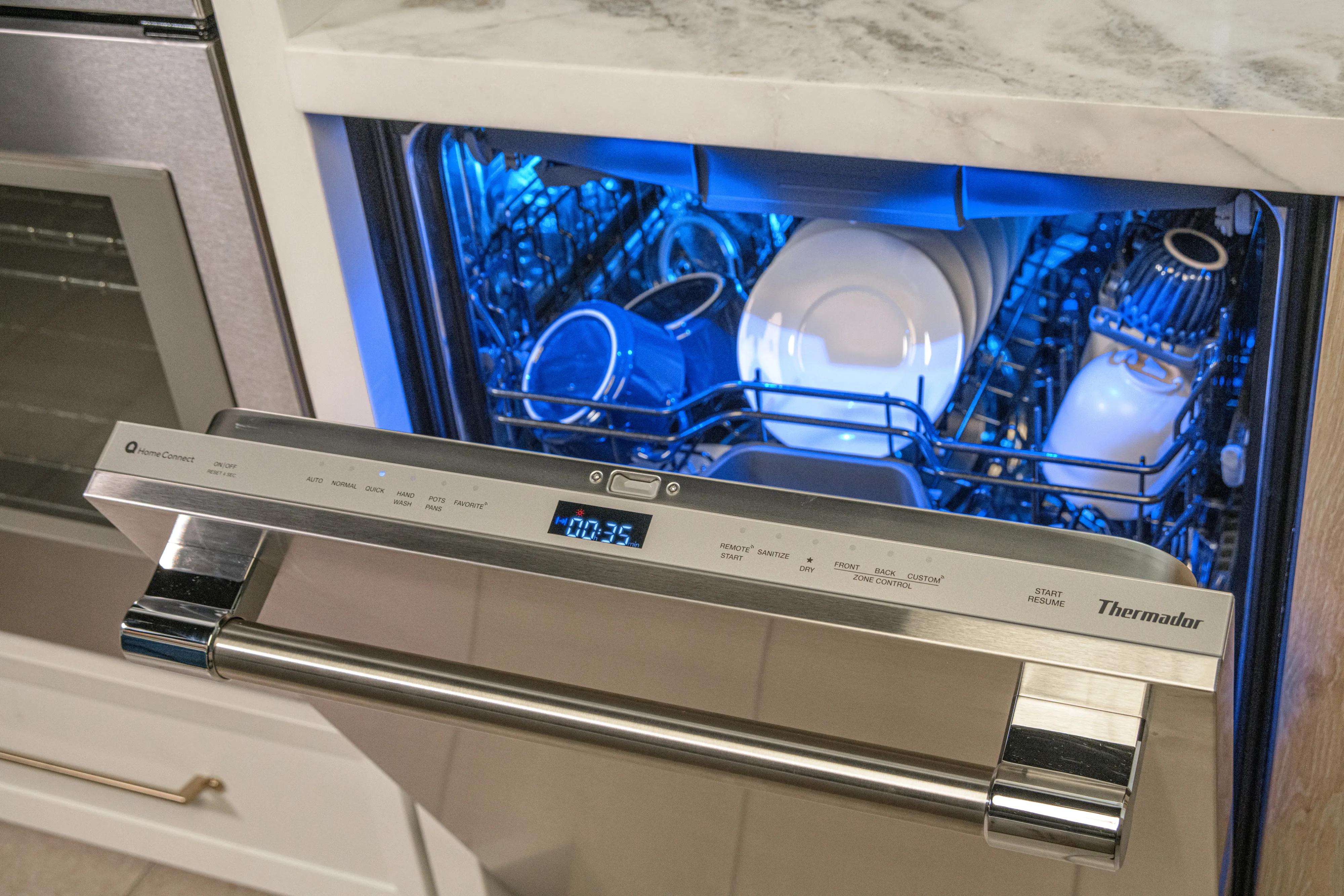 thermador high end dishwashers woman holding phone near dishwasher