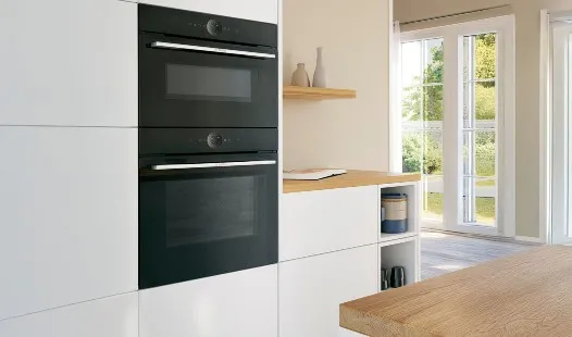 Cuisine moderne avec four et grille-pain, dotée d'armoires en bois clair et d'un comptoir élégant