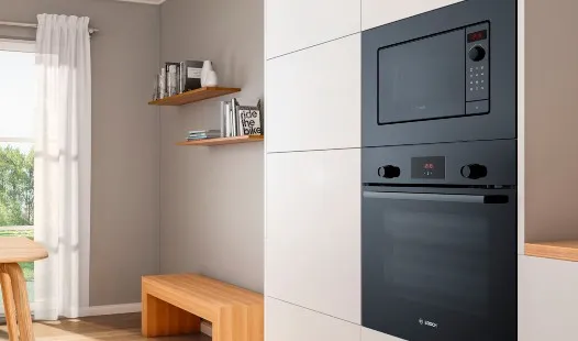 Cuisine moderne dotée d'armoires blanches élégantes, d'un comptoir en bois et de fours intégrés en acier inoxydable