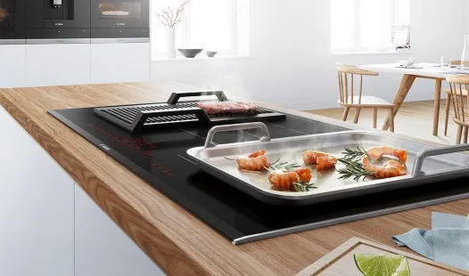 Cucina moderna con forno incorporato, elegante tostapane e arredamento minimalista con mobili in legno e un elegante piano di lavoro.